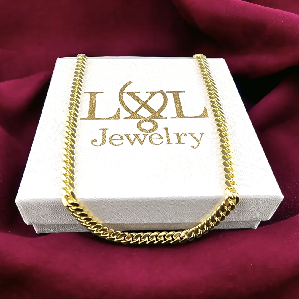 An exquisite gold chain necklace positioned atop a white jewelry box featuring the "LXL Jewelry" logo, set against a backdrop of maroon fabric.
